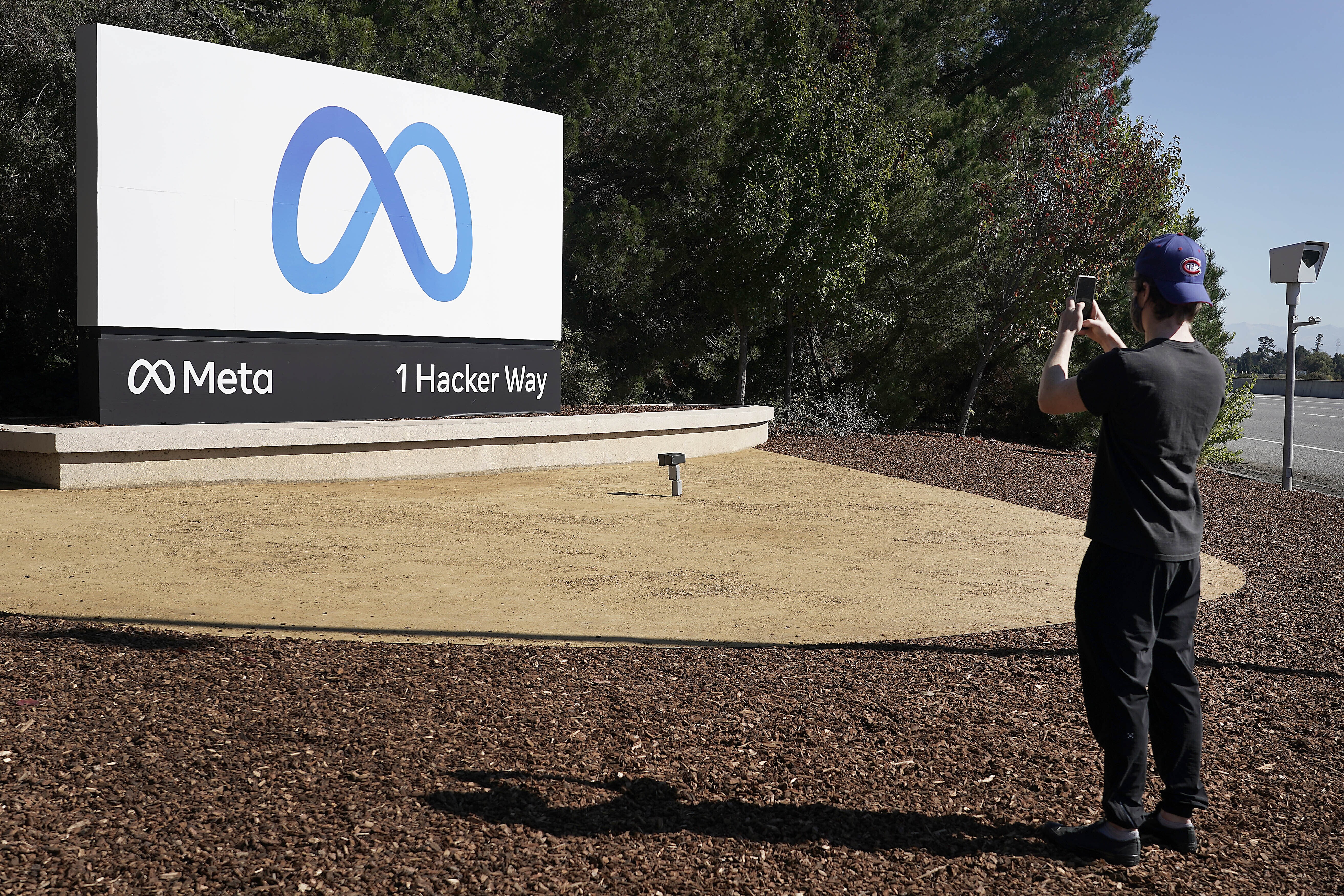 Facebook employee take a photo in front of new Meta Platforms Inc. sign outside the company headquarters in Menlo Park, Calif., Thursday, Oct. 28, 2021.